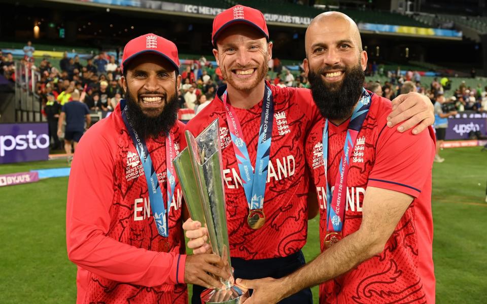 Adil Rashid (L), Jos Buttler (C) and Moeen Ali hold the trophy after England won the ICC Men's T20 World Cup Final match between Pakistan and England at the Melbourne Cricket Ground