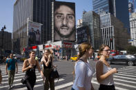 FILE - In this Sept. 6, 2018 file photo, people walk by a Nike advertisement featuring Colin Kaepernick in New York. In his "Just Do It" spot for Nike that marked the campaign's 30th anniversary in September, the sidelined-by-kneeling NFL quarterback somberly challenged viewers to "believe in something, even if it means sacrificing everything." Some responded with anger, cutting or burning Nike gear and calling for boycotts. President Donald Trump slammed the company's move, while LeBron James defended it, saying he stands for those who believe in change. (AP Photo/Mark Lennihan, File)