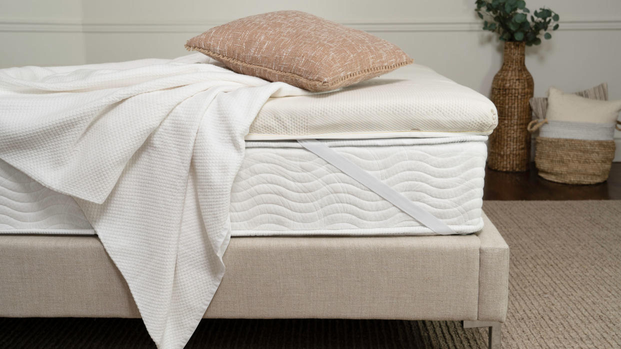  The Saatva Micro-Coil mattress topper on a bed. 