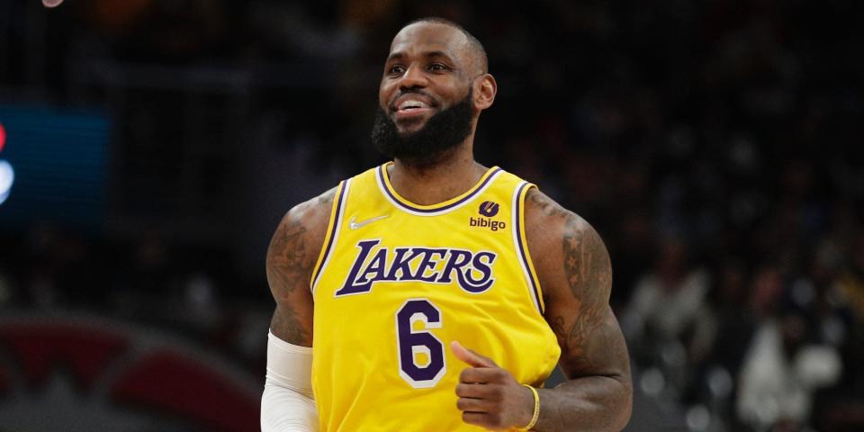 LeBron James smiles while running down the court in 2022.