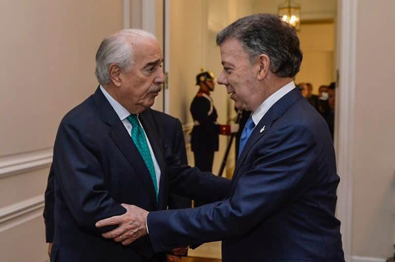Colombian President Juan Manuel Santos (R) welcomes Colombian former president Andres Pastrana during a meeting at Narino Palace in Bogota on October 5, 2016