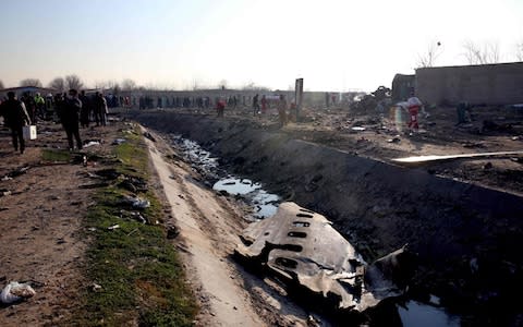 A side panel from the aircraft in a ditch - Credit: AFP