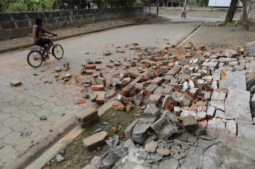 Un hombre pasa en bicicleta a un lado de una acera destrozada por el sismo del día anterior, en Nagarote, a unos 40km de Managua, el 11 de abril de 2014. (AFP | Inti Ocon)