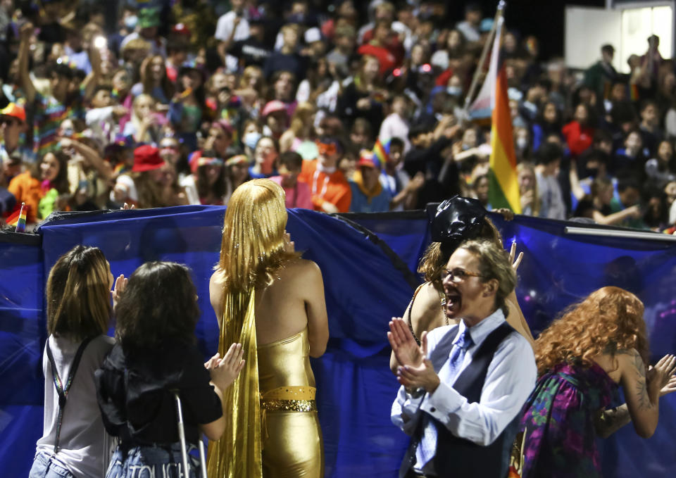 In this photo provided by Fritz Senftleber, people participate in the “drag ball" halftime show at Burlington High School on Friday, Oct. 15, 2021 in Burlington, Vt. The event was part of that school's homecoming and was sponsored by the Gender Sexuality Alliance from Burlington and South Burlington high schools. The football game was between a team made up of students from three Burlington-area schools Burlington, South Burlington and Winooski High Schools who played against St. Johnsbury Academy. (Fritz Senftleber via AP)