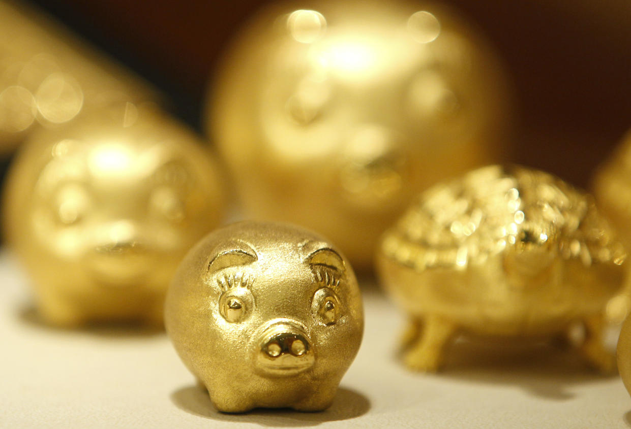 Gold pigs are displayed for customers at a jewellery shop at the Shinsegae department store in Seoul August 1, 2011. REUTERS/Jo Yong-Hak (SOUTH KOREA - Tags: BUSINESS)
