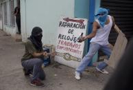 Opositores lanzan bombas molotov durante un enfrentamiento con la policía en la protesta contra el gobierno de Nicolás Maduro, en Valencia Venezuela, el miércoles 26 de febrero de 2014. Las protestas iniciaron con estudiantes en distintas ciudades, quienes están molestos por el crimen, los problemas económicos y la mano dura con la que la policía les ha respondido. (AP Photo/Rodrigo Abd)