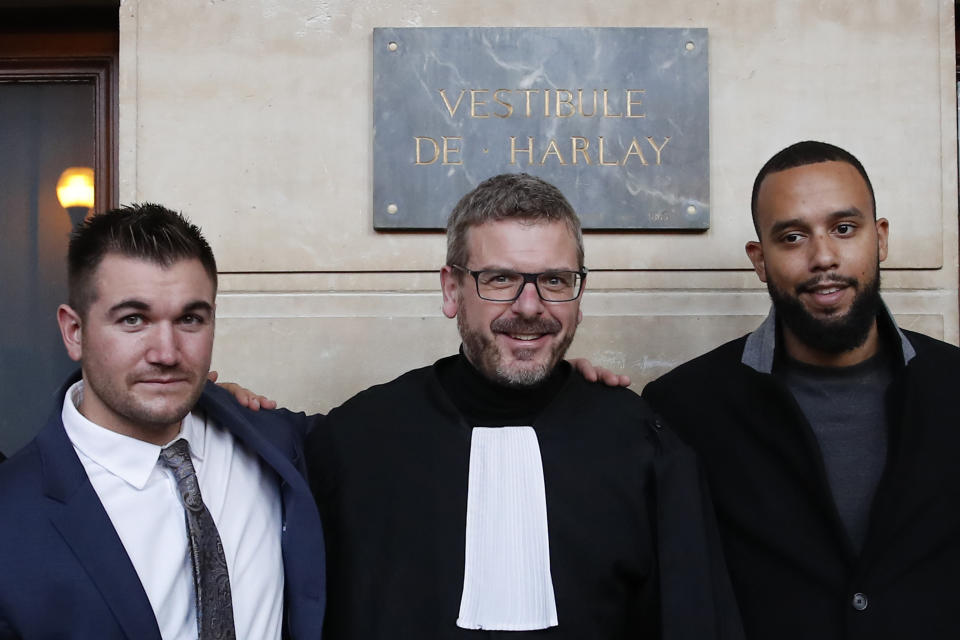 Alek Skarlatos, left, Anthony Sadler, right, and their lawyer Thibault de Montbrial, pose for photographers at the end of their hearing during the Thalys attack trial at the Paris courthouse, Friday, Nov. 20, 2020. Passengers who wrestled and disarmed an Islamic State gunman aboard a high-speed Amsterdam to Paris train are recounting how their split-second decisions helped prevent what could have become a mass slaughter. (AP Photo/Francois Mori)