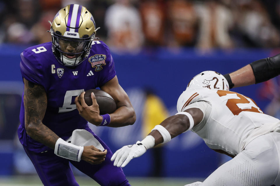 Washington quarterback Michael Penix Jr. (9) runs against Texas defensive back Kitan Crawford (21) during the second half of the Sugar Bowl CFP NCAA semifinal college football game, Monday, Jan. 1, 2024, in New Orleans. (AP Photo/Butch Dill)