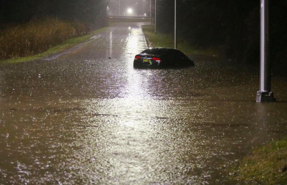 A car is abandoned in high water at the ramp from Centervllle Road to Kirkwood Highway late Tuesday evening, Jan. 9, 2024 as a storm brings high winds and heavy rain to Delaware.