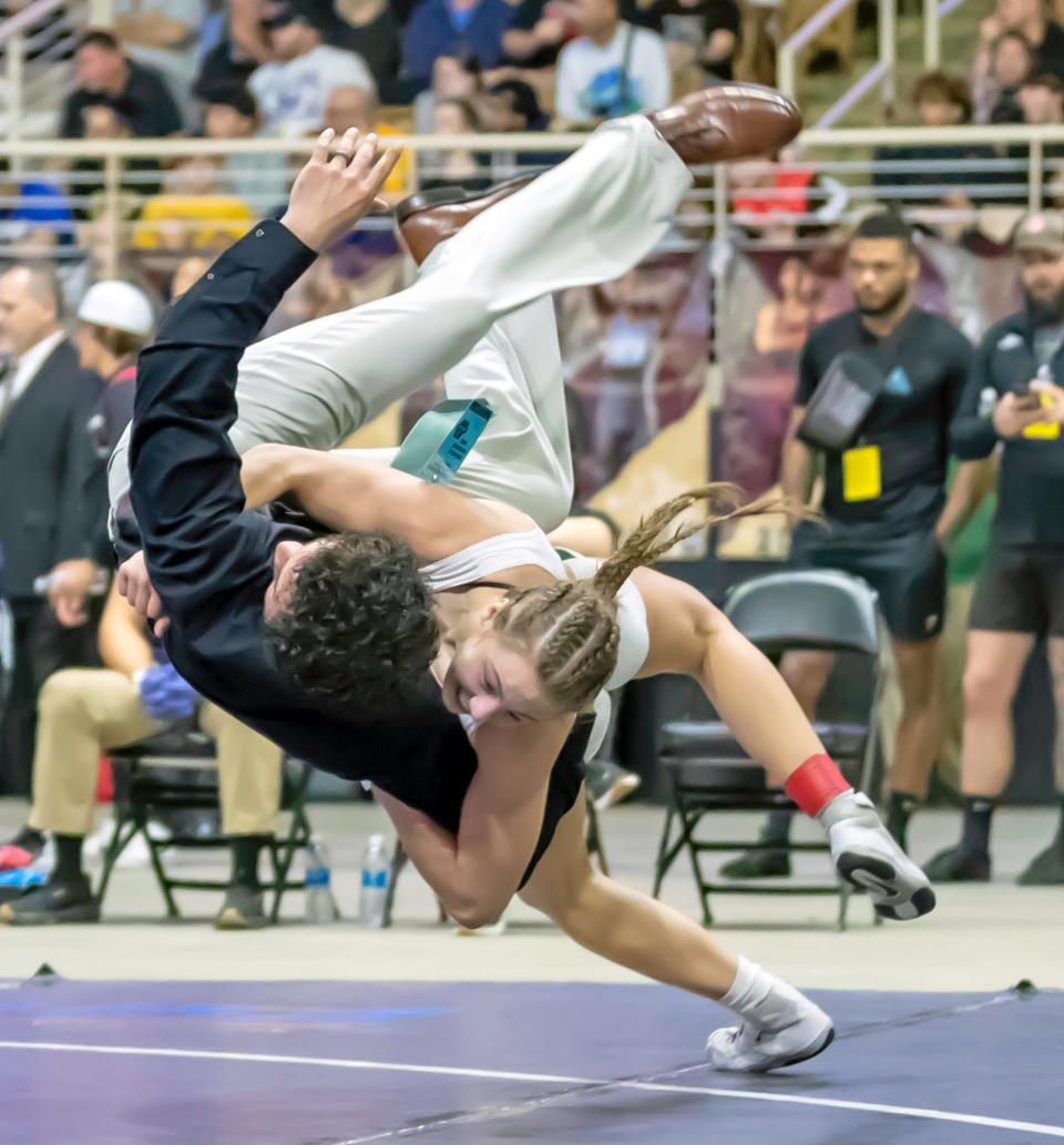 Venice High wrestler Milana Borrelli tosses Coach Jeremie Cook after winning her second state championship in the 120-pound weight class at the FHSAA State Championships on March 2 at Silver Spurs Arena in Kissimmee.