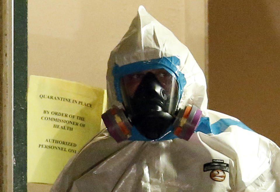 A worker in a hazardous material suit steps out of an apartment unit where a man diagnosed with the Ebola virus was staying in Dallas, Texas, October 5, 2014. The first Ebola patient diagnosed in the United States took a turn for the worse on Saturday, slipping from serious to critical condition in a Dallas hospital, as health officials reported tracking scores of possible cases around the country that proved to be false alarms. REUTERS/Jim Young (UNITED STATES - Tags: HEALTH)