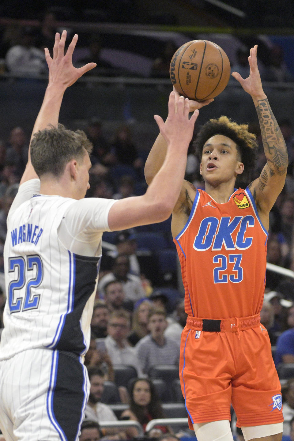 Oklahoma City Thunder guard Tre Mann (23) shoots in front of Orlando Magic forward Franz Wagner (22) during the first half of an NBA basketball game, Sunday, March 20, 2022, in Orlando, Fla. (AP Photo/Phelan M. Ebenhack)