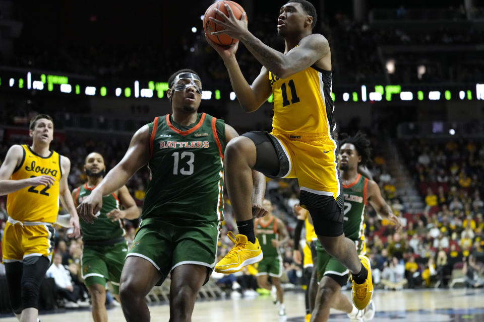 Iowa guard Tony Perkins (11) drives to the basket past Florida A&M forward Shannon Grant (13) during the first half of an NCAA college basketball game, Saturday, Dec. 16, 2023, in Des Moines, Iowa. (AP Photo/Charlie Neibergall)