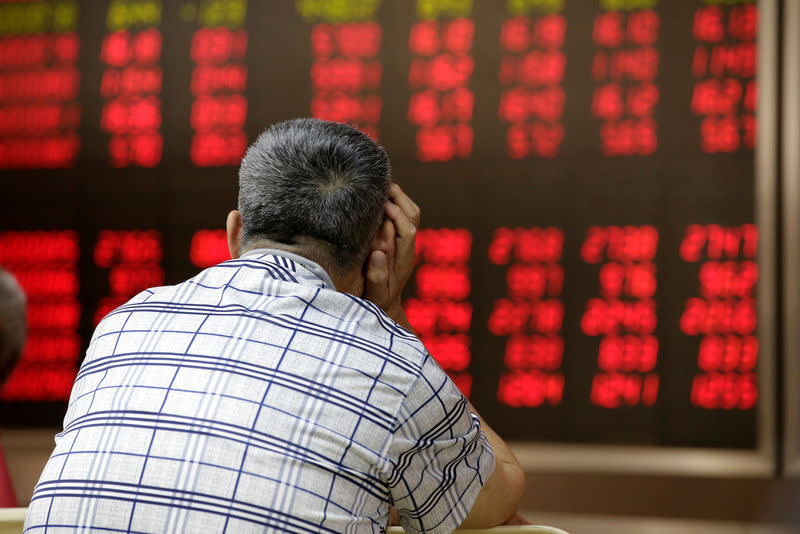 An investor looks at an electronic board showing stock information at a brokerage house in Beijing, China, June 24, 2016. REUTERS/Jason Lee