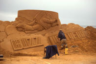 <p>A sand carver works on a sculpture during the Sand Sculpture Festival “Disney Sand Magic” in Ostend, Belgium. (Photo courtesy of Disneyland Paris) </p>