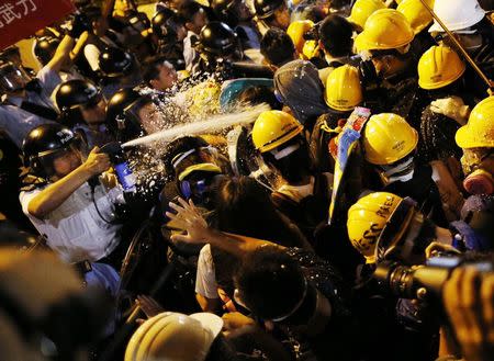 Police use pepper spray during clashes with pro-democracy protesters close to the chief executive office in Hong Kong in this November 30, 2014 file photo. REUTERS/Tyrone Siu/File