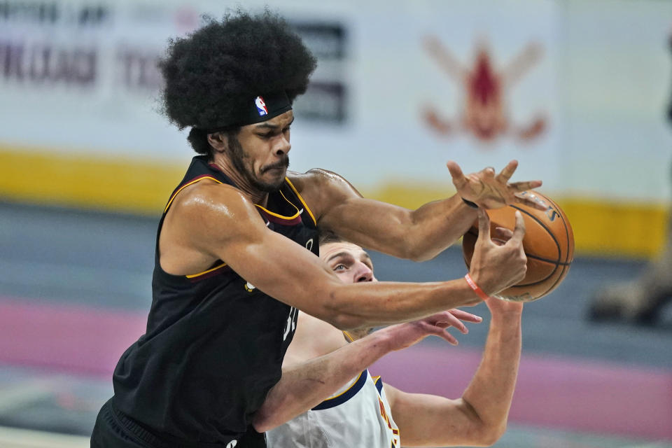 Cleveland Cavaliers' Jarrett Allen, left and Denver Nuggets' Nikola Jokic reach for the ball during the first half of an NBA basketball game, Friday, Feb. 19, 2021, in Cleveland. (AP Photo/Tony Dejak)