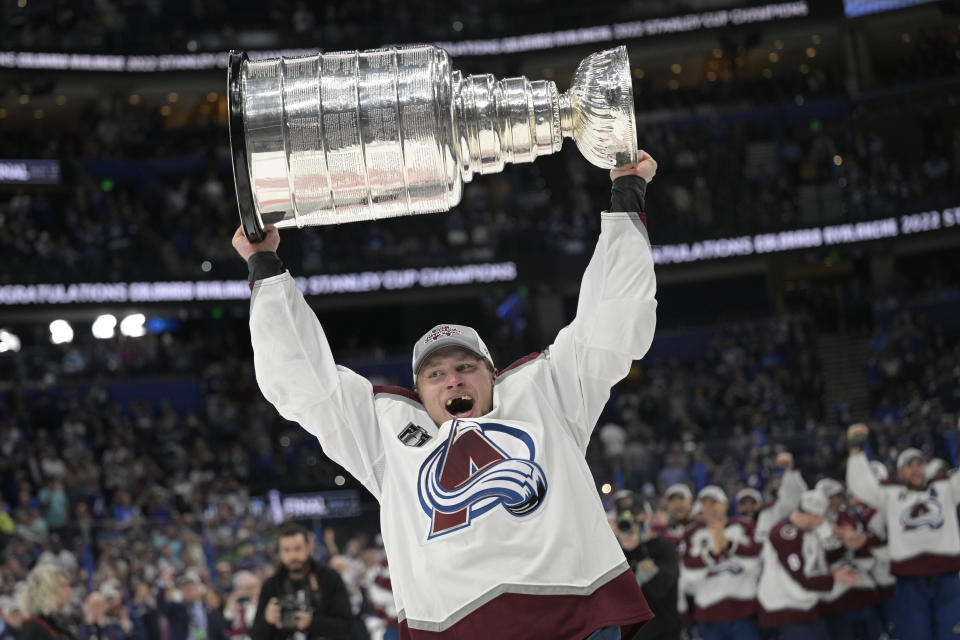 FILE - Colorado Avalanche defenseman Erik Johnson lifts the Stanley Cup after the team defeated the Tampa Bay Lightning in Game 6 of the NHL hockey Stanley Cup Finals on Sunday, June 26, 2022, in Tampa, Fla. All the Stanley Cup parties and parades are over for the Colorado Avalanche. The shorter-than-most summer has run its fun-loving, Cup-hoisting course and training camp has arrived. It's time to get back to the task of defending the title. (AP Photo/Phelan Ebenhack, File)