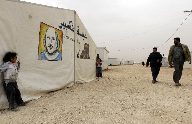 Syrian refugees walk past the 'Shakespeare tent' where children are rehearsing King Lear, one of Shakespeare's great tragedies, at the sprawling Zaatari refugee camp in Jordanian desert near the border with Syria, on March 8, 2014