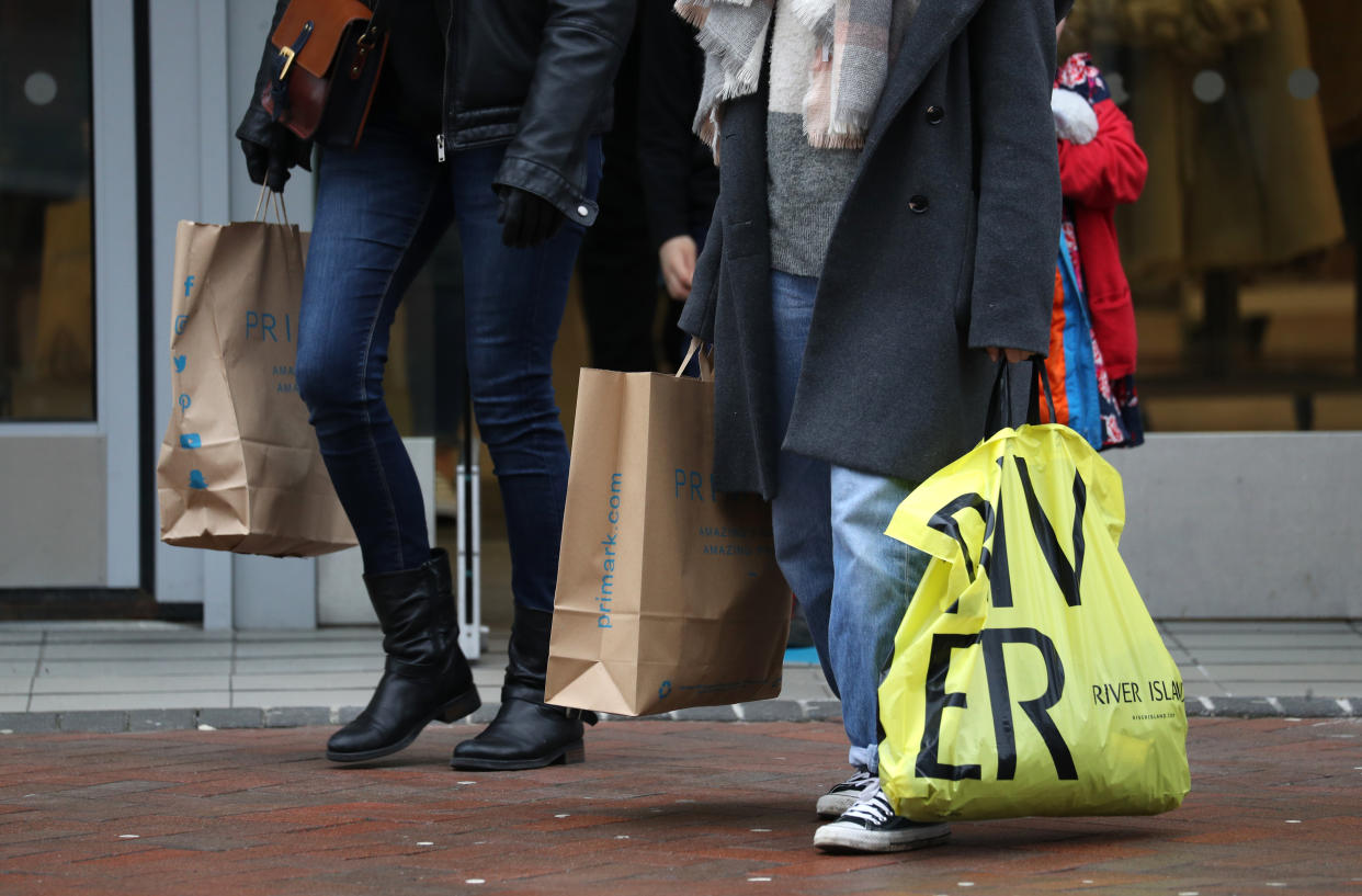 People carrying shopping bags in Bournemouth. UK consumer confidence fell again