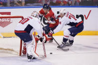 Florida Panthers left wing Ryan Lomberg (94) and Washington Capitals defenseman John Carlson (74) battle for the puck as goaltender Ilya Samsonov (30) guards the net during the first period of an NHL hockey game, Tuesday, Nov. 30, 2021, in Sunrise, Fla. (AP Photo/Wilfredo Lee)