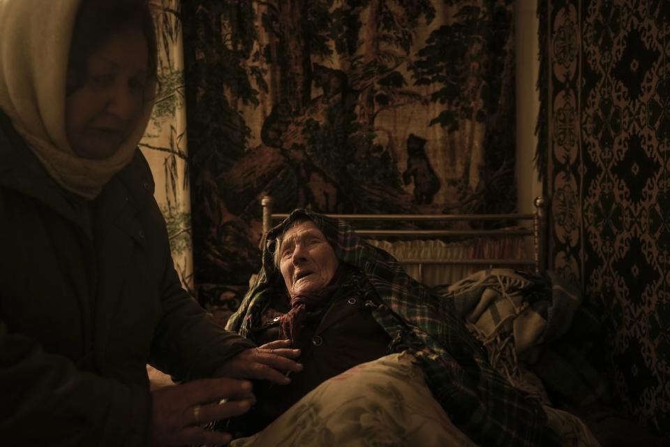 Motria Oleksiienko, 99, traumatized by the Russian occupation, is comforted by daughter-in-law Tetiana Oleksiienko in a room without heating in the village of Andriivka, Ukraine, which was heavily affected by fighting between Russian and Ukrainian forces, April 6, 2022. The image was part of a series of images by Associated Press photographers that was a finalist for the 2023 Pulitzer Prize for Feature Photography. (AP Photo/Vadim Ghirda)