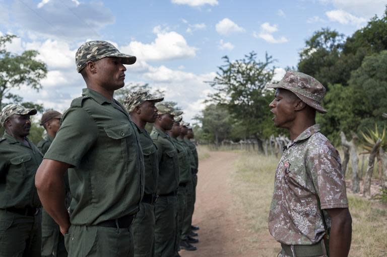 Staff Sergeant Wilfred Radebe (R) calls new recruits to attention during their training to become armed anti-poaching rangers at the Nkwe Wildlife and Security Services in Vaalwater in Limpopo Province on March 17, 2015