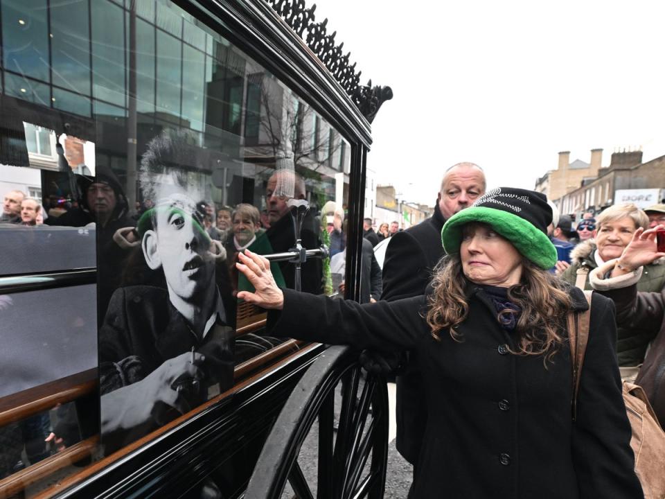 Fans touch the glass window of the carriage during the funeral procession (Getty Images)