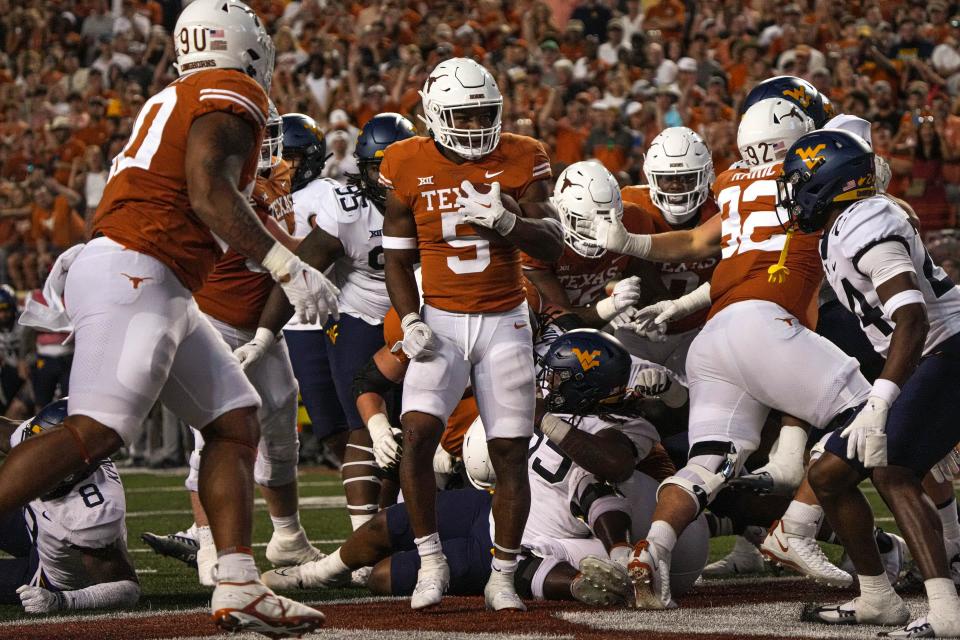 Texas running back Bijan Robinson celebrates a 1-yard touchdown run in the first half of Saturday's game against West Virginia. It was Robinson's 30th career touchdown.