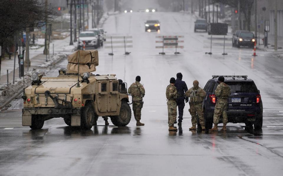 Michigan National Guard and Lansing Police officers patrol at a closed street outside the state capitol in Lansing - AP