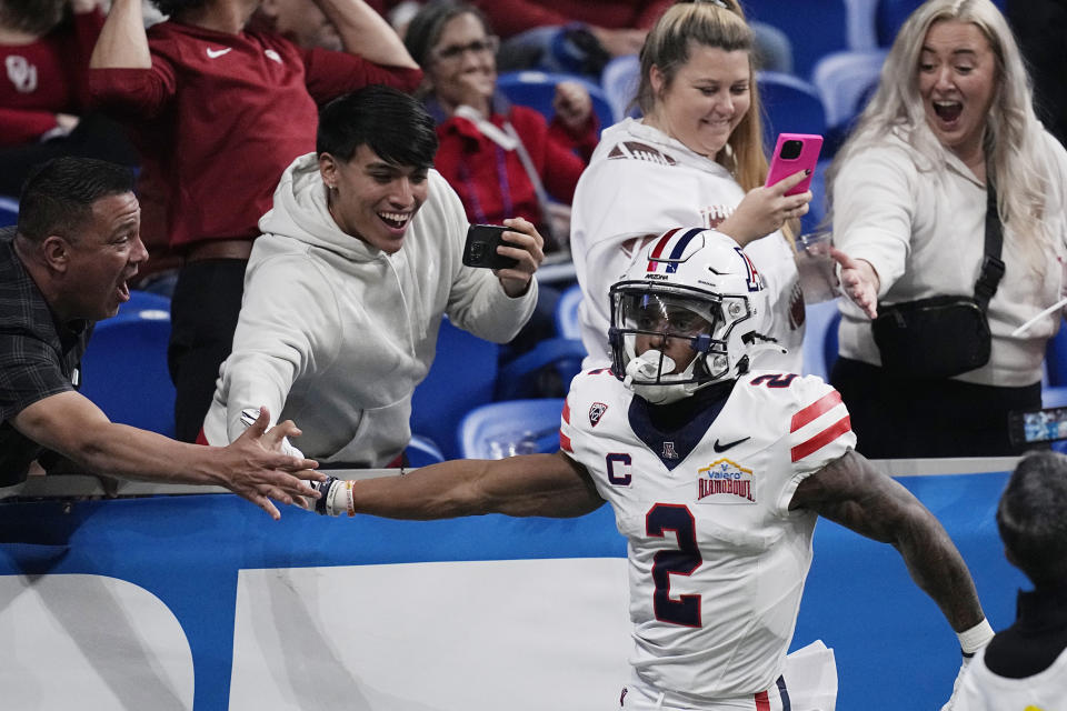 Arizona wide receiver Jacob Cowing (2) celebrates with fans after a touchdown catch against Oklahoma during the first half of the Alamo Bowl NCAA college football game in San Antonio, Thursday, Dec. 28, 2023. (AP Photo/Eric Gay)