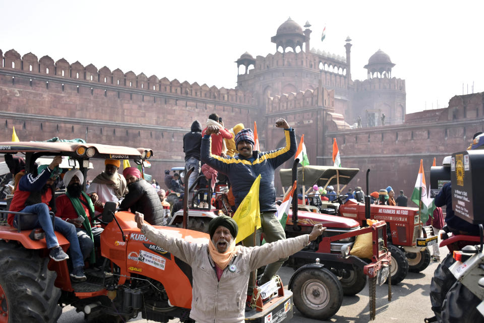 NEW DELHI, INDIA - JANUARY 26: Demonstrators at Red Fort during the farmers' tractor rally on Republic Day, on January 26, 2021 in New Delhi, India. Major scenes of chaos and mayhem at Delhi borders as groups of farmers allegedly broke barricades and police check posts and entered the national capital before permitted timings. Police used tear gas at Delhi's Mukarba Chowk to bring the groups under control. Clashes were also reported at ITO, Akshardham. Several rounds of talks between the government and protesting farmers have failed to resolve the impasse over the three farm laws. The kisan bodies, which have been protesting in the national capital for almost two months, demanding the repeal of three contentious farm laws have remained firm on their decision to hold a tractor rally on the occasion of Republic Day.(Photo by Sanjeev Verma/Hindustan Times via Getty Images)