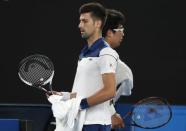 Tennis - Australian Open - Rod Laver Arena, Melbourne, Australia, January 22, 2018. Chung Hyeon of South Korea and Novak Djokovic of Serbia walk past each other during their match. REUTERS/Issei Kato