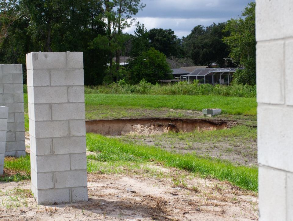 A series of concrete columns indicate the early stages of construction along Aiden Lane, close to the location of a sinkhole that formed Friday afternoon. It is the second sinkhole in three months at the site near Scott Lake.