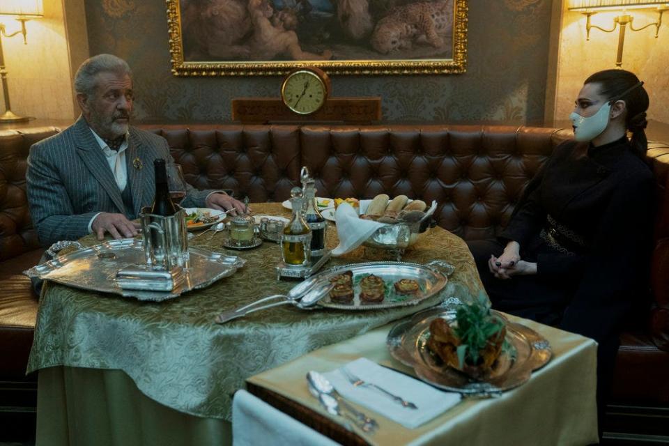 Crime boss Cormac (Mel Gibson) gets a visit from the High Table's Adjudicator (Katie McGrath) in "The Continental."