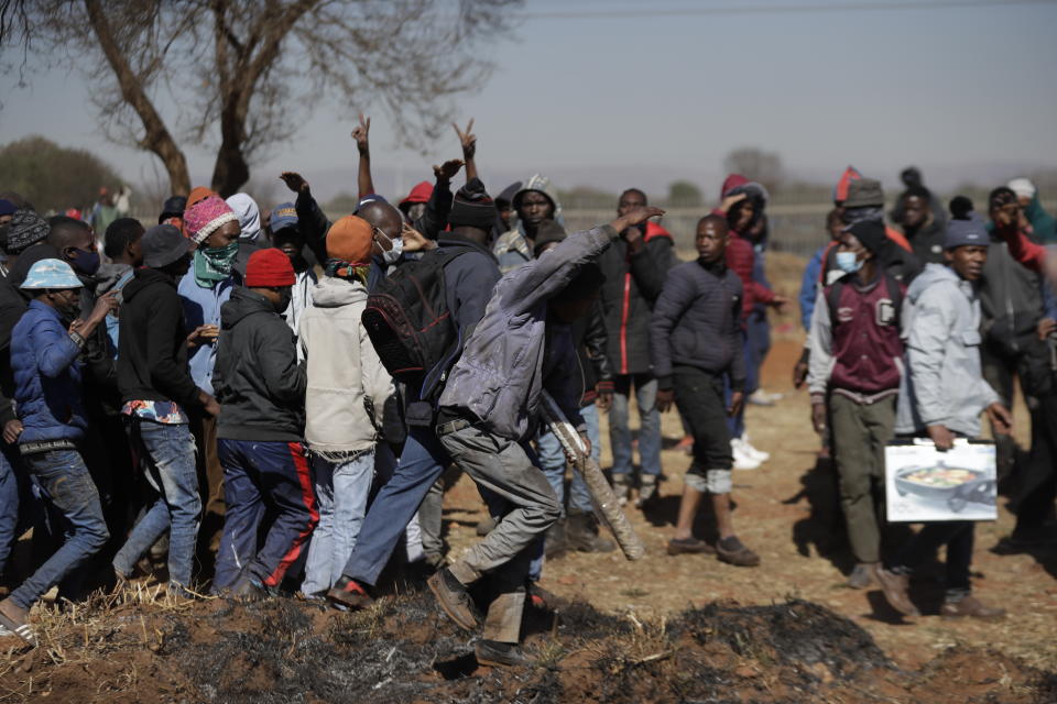 A group of men shout as they try to enter a shopping mall in Vosloorus, east of Johannesburg, South Africa, Wednesday July 14, 2021. South Africa's rioting continued Wednesday as police and the military struggle to quell the violence in Gauteng and KwaZulu-Natal provinces. The violence started in various parts of KwaZulu-Natal last week when Zuma began serving a 15-month sentence for contempt of court. (AP Photo/Themba Hadebe)