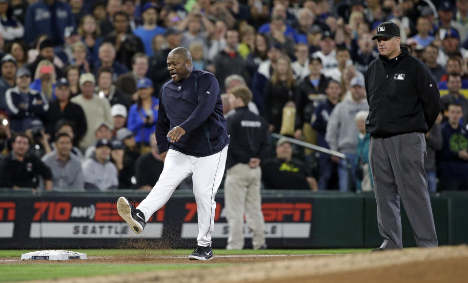 Umpire Tony Randazzo, right, looks on as Seattle Mariners manager Lloyd McClendon kicks along the third baseline after being ejected in the third inning of a baseball game Tuesday, June 2, 2015, in Seattle. (AP Photo/Elaine Thompson)