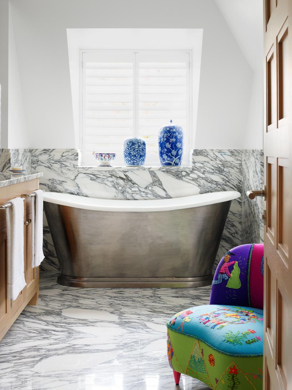 The master bath features a C.P. Hart tub. Embroidered chair by Minnie.