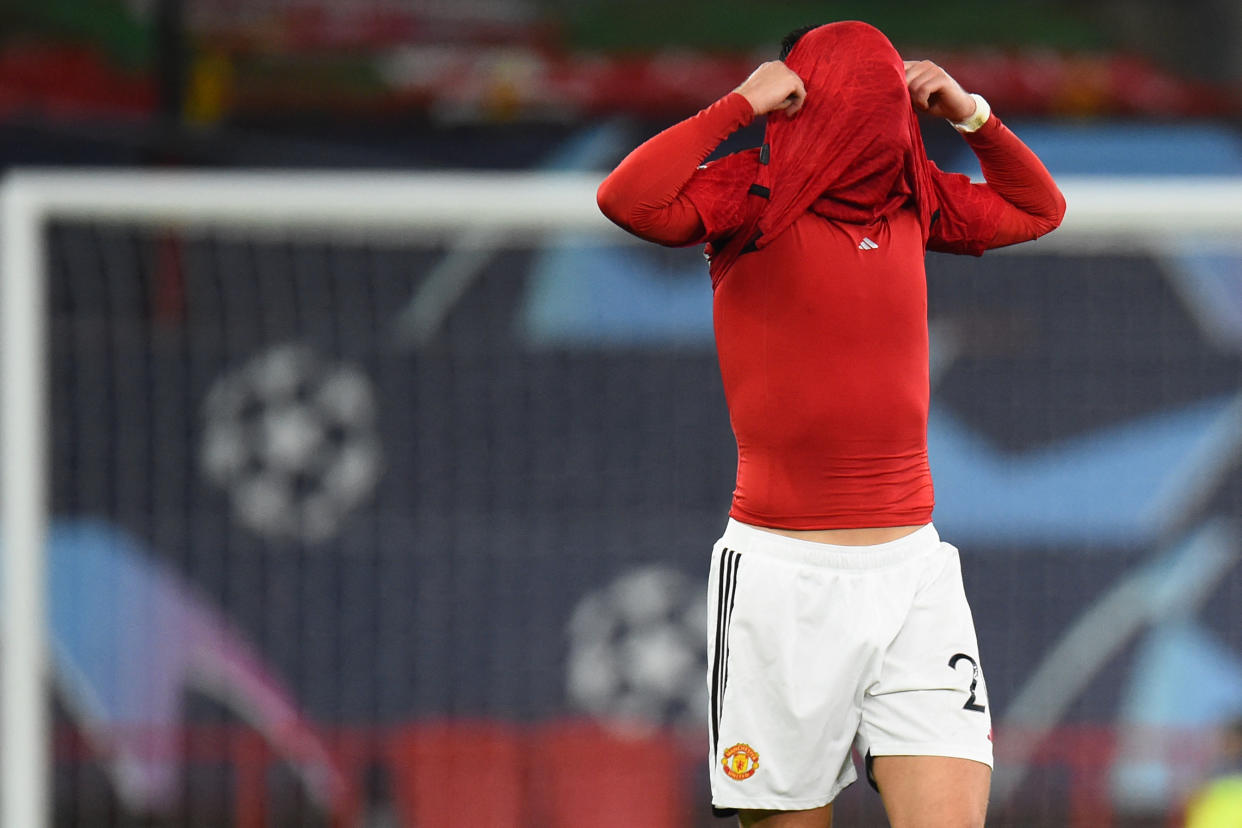 Manchester United's Diogo Dalot covers his face after their Champions League loss to Bayern Munich on Tuesday. (Photo by PETER POWELL/AFP via Getty Images)
