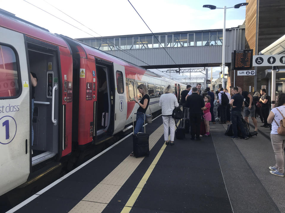 Passengers wait for news during travel disruption on the East Coast mainline at Peterborough Station, Peterborough, England, Friday, Aug. 9, 2019. London and large chunk of the U.K. were hit with a power cut Friday afternoon that disrupted train travel and snarled rush-hour traffic. U.K. Power Networks, which owns and maintains electricity cables in London and southern England, said a network failure at power supplier National Grid was affecting its customers. (Martin Keene/PA via AP)