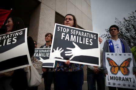 People hold signs at a protest against plans to deport Central American asylum seekers in Los Angeles, California, U.S., May 17, 2016. REUTERS/Lucy Nicholson