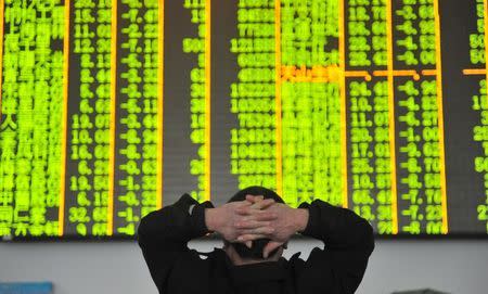 An investor looks at an electronic screen at a brokerage house in Hangzhou, Zhejiang province, January 26, 2016. REUTERS/China Daily