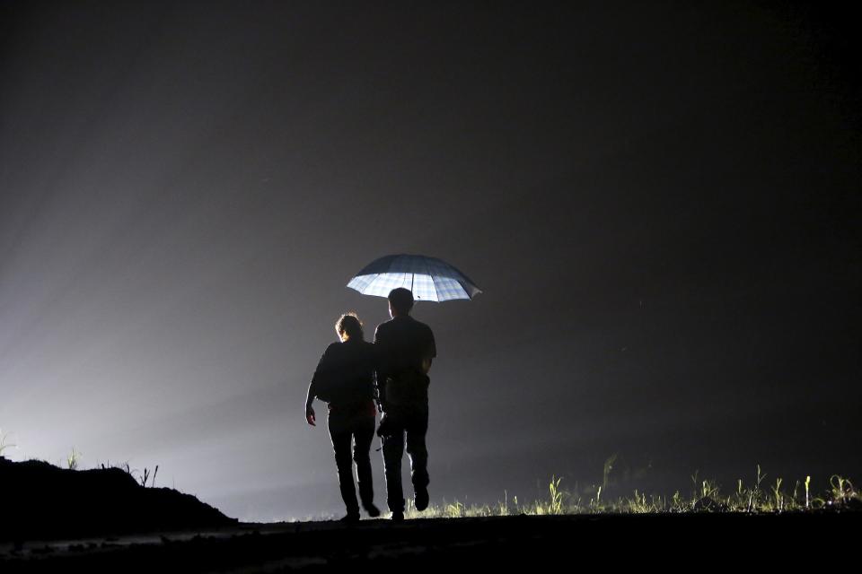 Relatives of a missing passenger aboard a sunken ship walk on the bank of Yangtze River in Jianli section, Hubei province, China, June 2, 2015. Rescuers fought bad weather on Tuesday as they searched for more than 400 people, many of them elderly Chinese tourists, missing after a cruise boat was buffeted by a freak tornado and capsized on the Yangtze River. (REUTERS/Aly Song)