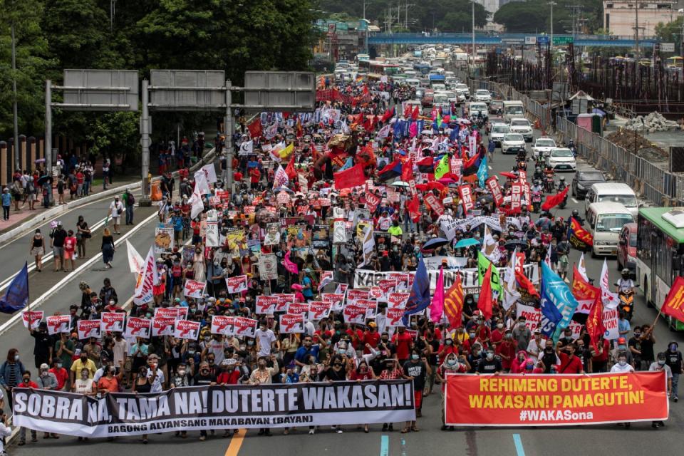 Thousands of Filipinos carrying placards, banners and props march in a protest organized by BAYAN in Quezon City, Philippines.