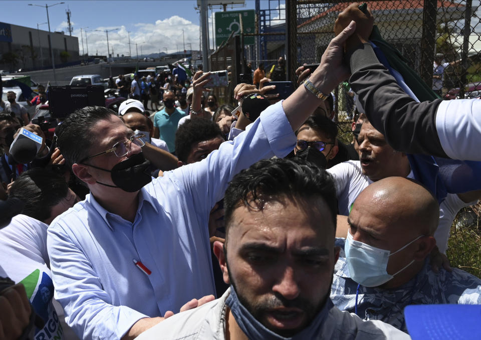 Presidential candidate Rodrigo Chaves greets supporters upon his arrival at a polling station during a runoff presidential election, in San Jose, Costa Rica, Sunday, April 3, 2022. Rodrigo Chaves a treasury minister from Costa Rica's outgoing administration and Jose Maria Figueres a former president, face off to become the country's next leader. (AP Photo/Carlos Gonzalez)