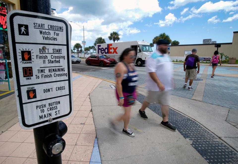 Two pedestrians cross State Road A1A while two others head across Main Street in Daytona Beach on Monday. The area sees a lot of tourists making their way around to see the sights, putting them in conflict with vehicles traveling through.