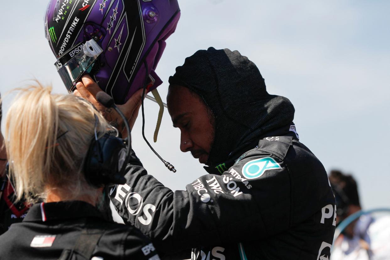 Lewis Hamilton puts on his helmet before the start of the Mexico Grand Prix.