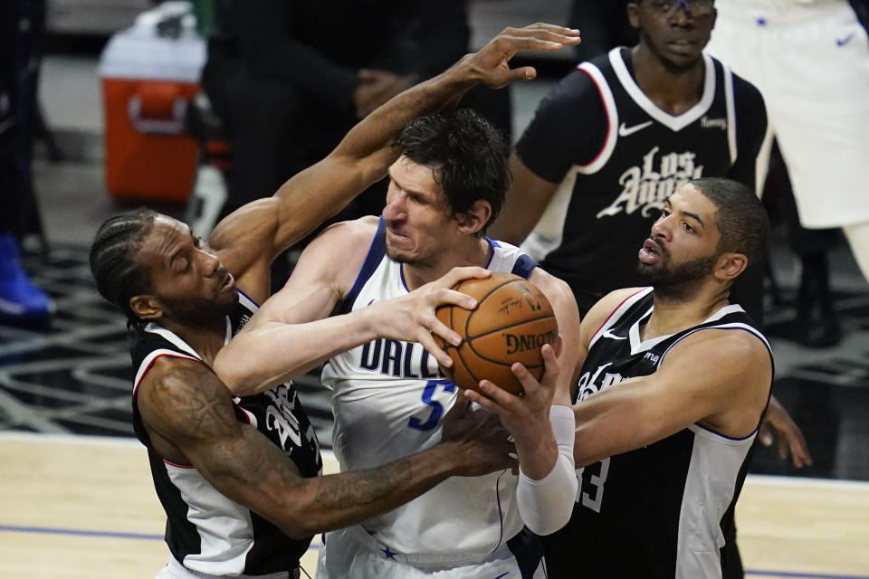 Los Angeles Clippers forward Kawhi Leonard, left, and forward Nicolas Batum, right, defend against Dallas Mavericks center Boban Marjanovic (51) during the third quarter of Game 7 of an NBA basketball first-round playoff series Sunday, June 6, 2021, in Los Angeles, Calif. (AP Photo/Ashley Landis)