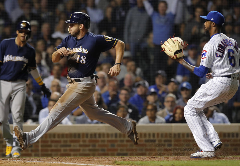 Milwaukee Brewers' Mike Moustakas comes in to score on a wild pitch by Chicago Cubs' Carl Edwards Jr., right, during the sixth inning of a baseball game Monday, Sept. 10, 2018, in Chicago. (AP Photo/Jim Young)