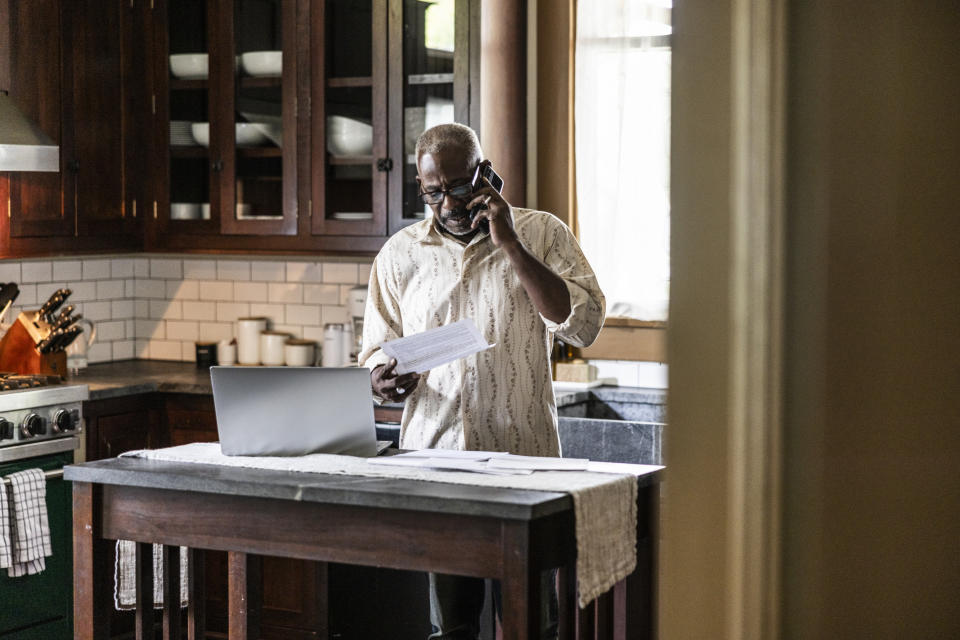 older black man on the phone in the kitchen